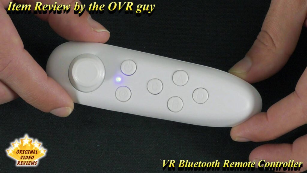 The OVR Guy holding the VR Bluetooth Remote Controller in a close-up top view, showing all buttons and controls