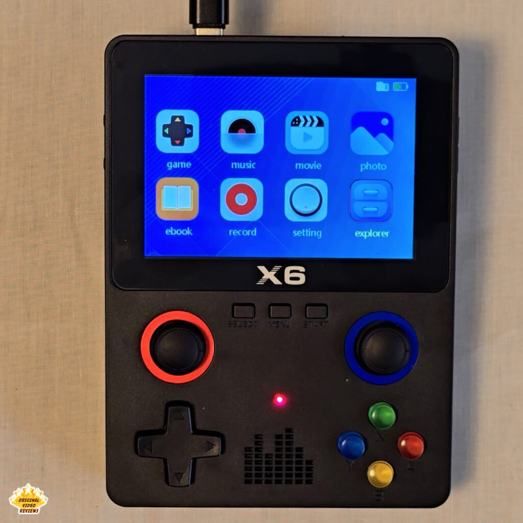 X6 handheld console main menu screen with red charging LED indicator