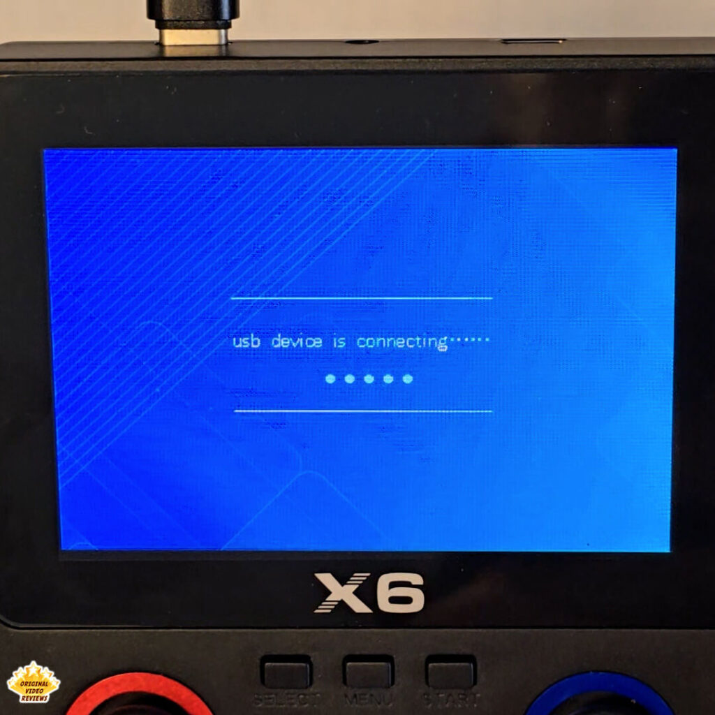 X6 handheld console displaying “USB device is connecting” screen