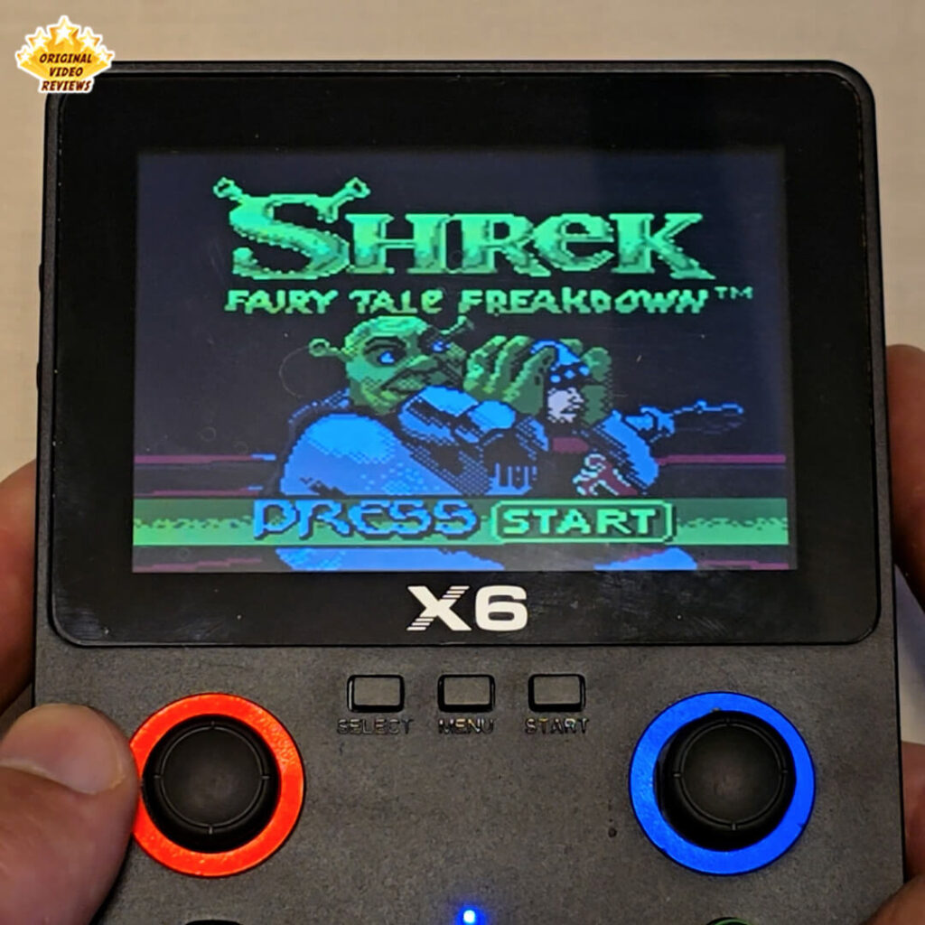 X6 handheld console displaying the title screen of the retro game Shrek: Fairy Tale Freakdown with the "Press Start" prompt.