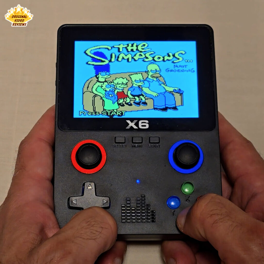X6 handheld console displaying the title screen of the game The Simpsons.