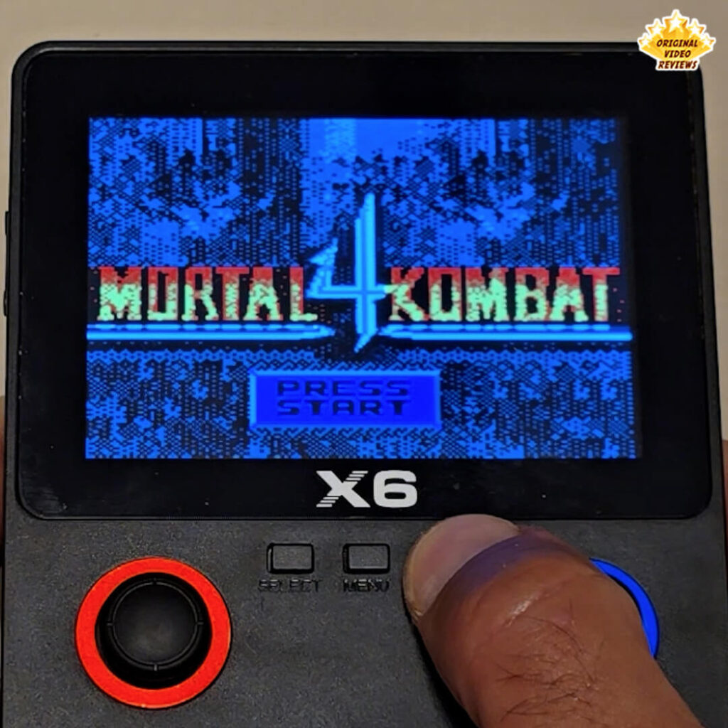 X6 handheld console displaying the title screen of the game Mortal Kombat 4.