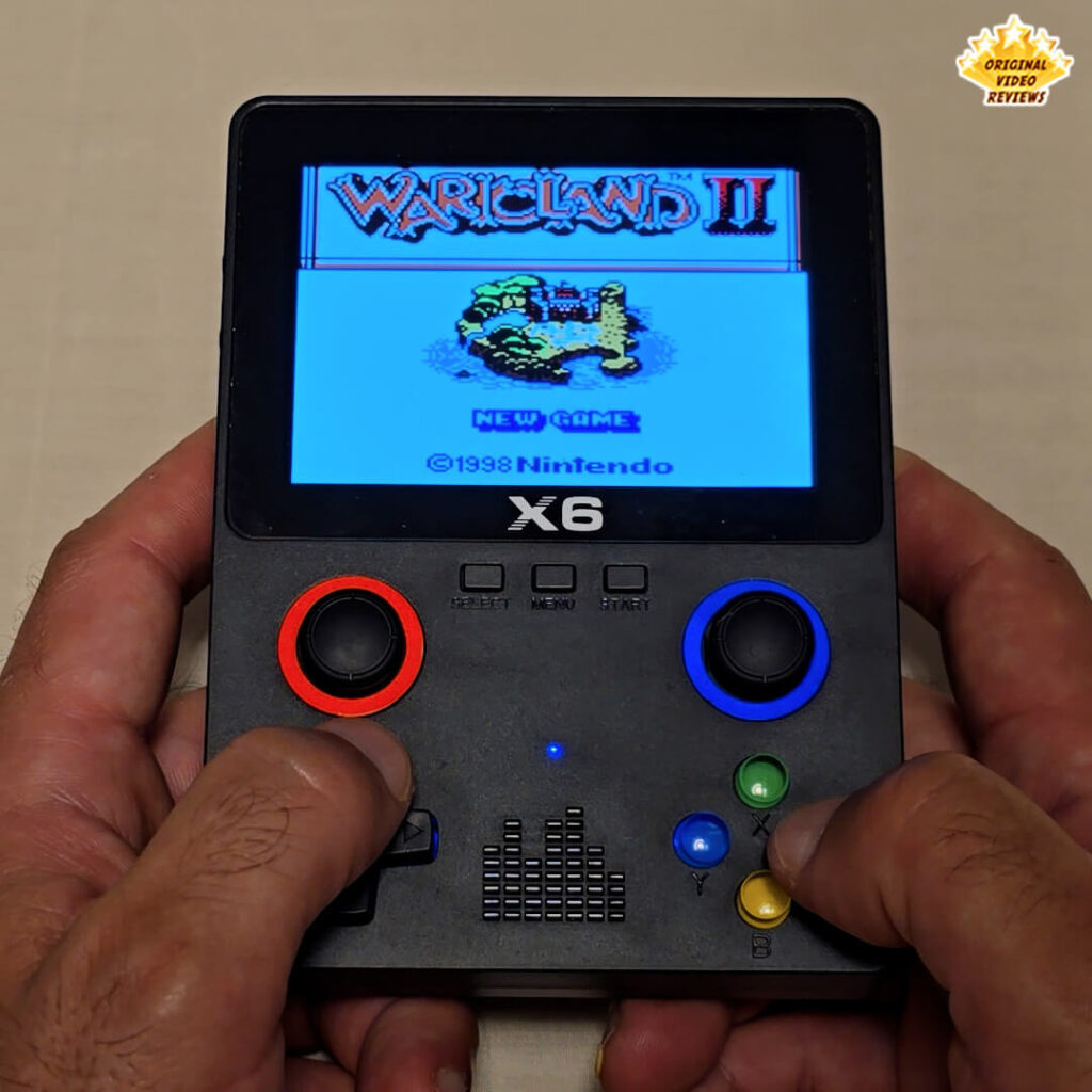X6 handheld console displaying the title screen of the game Wario Land II.
