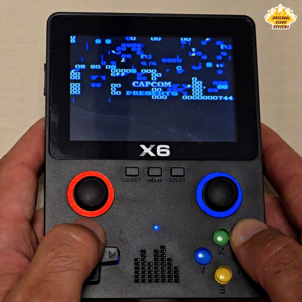 X6 handheld console showing a corrupted screen with unreadable text and graphics glitches.
