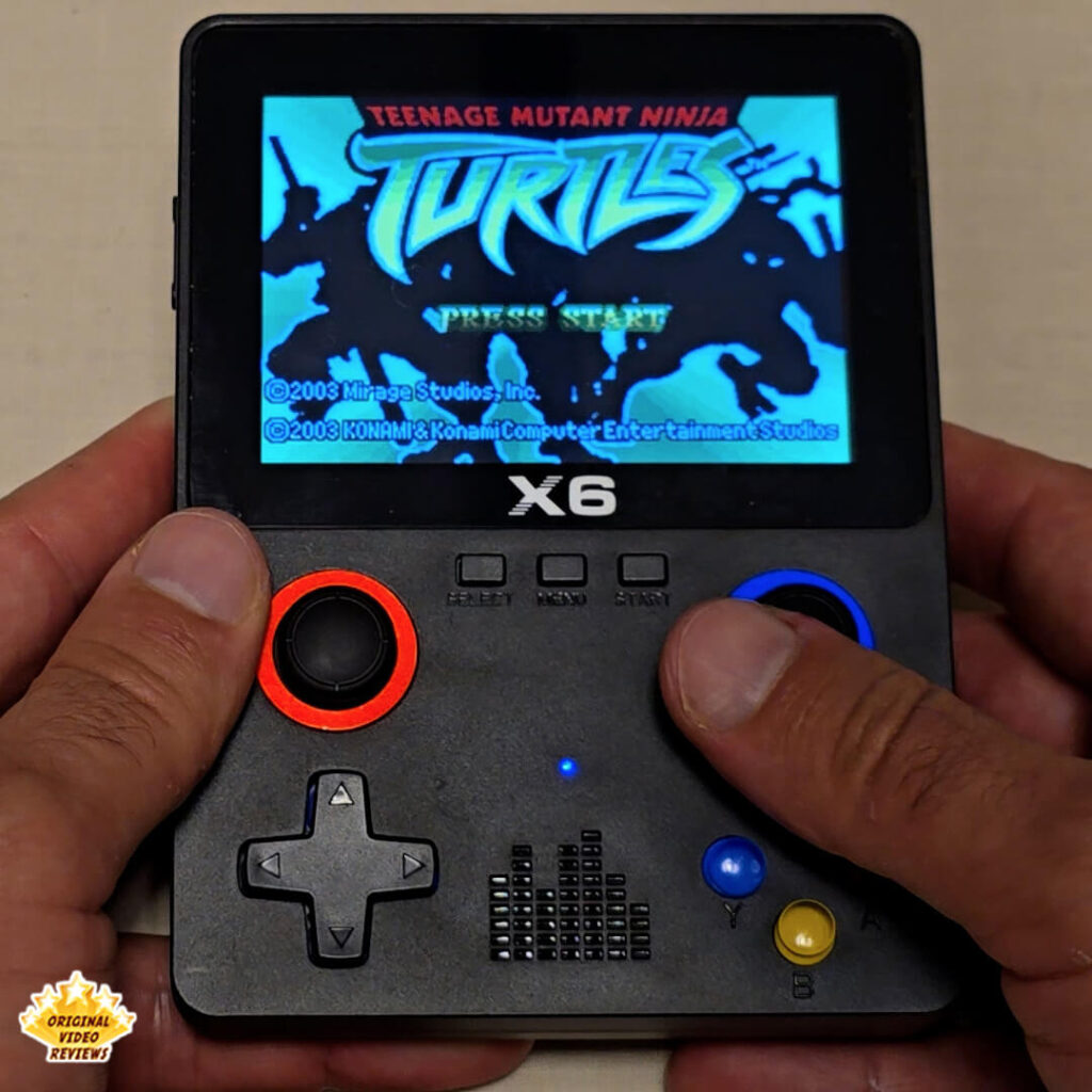 Close-up of the X6 handheld gaming console screen showing the title screen of Teenage Mutant Ninja Turtles.