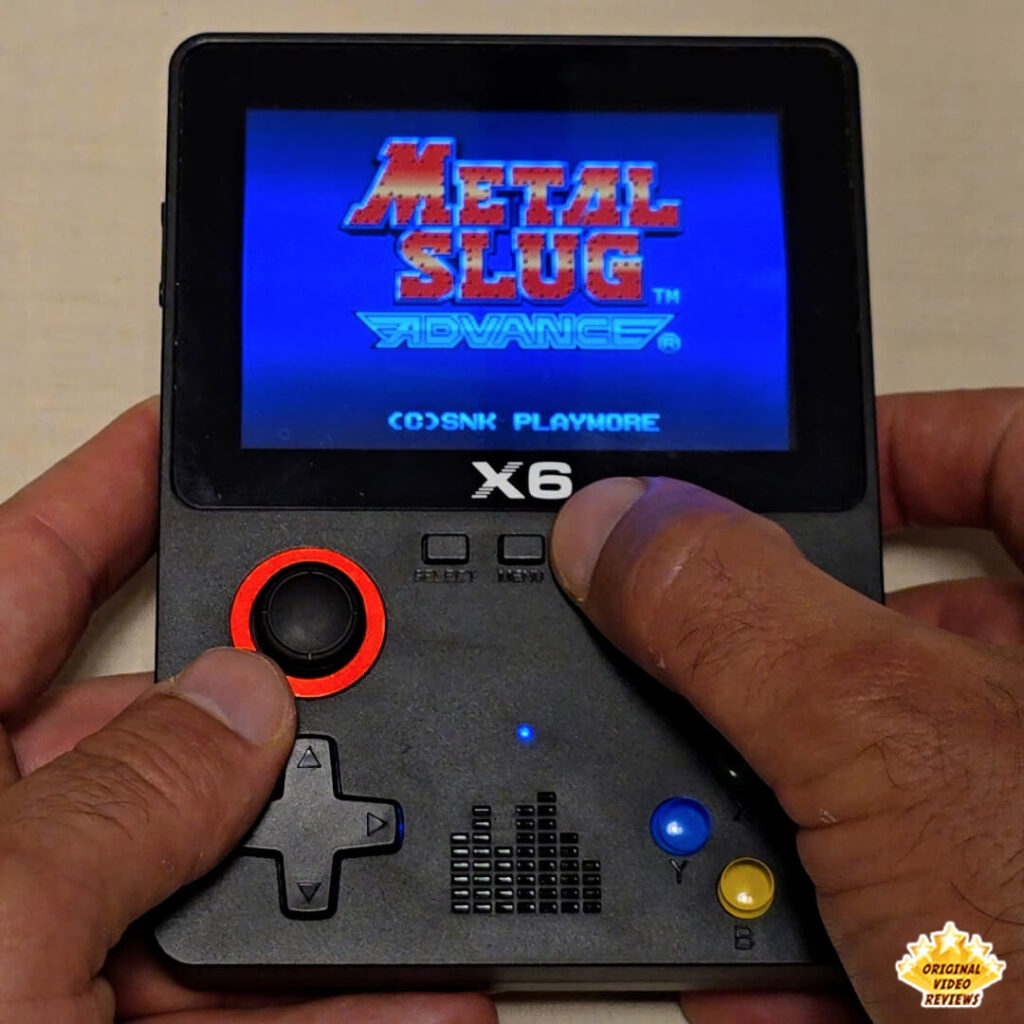 Close-up of the X6 handheld gaming console screen showing the title screen of Metal Slug Advance.