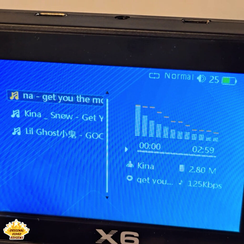 Close-up of the X6 handheld retro gaming console showing the MP3 player interface.