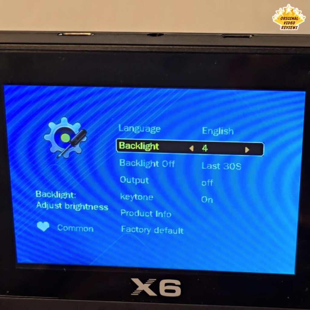 X6 console settings menu screen showing language, backlight, and output configuration options.
