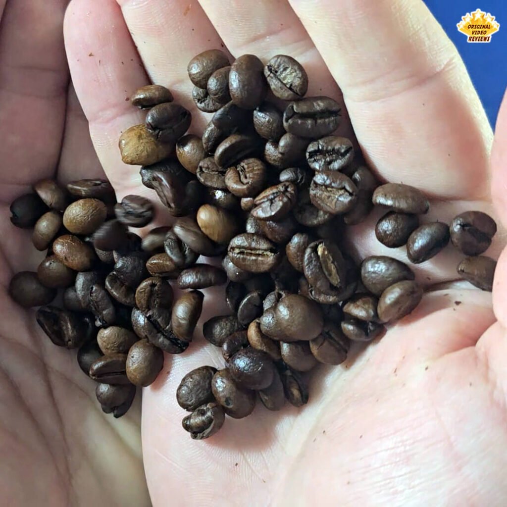 The OVR Guy holding a handful of Bristot Classico Oro coffee beans, showing the medium roast blend with a balanced range of colors and a pleasant aroma.