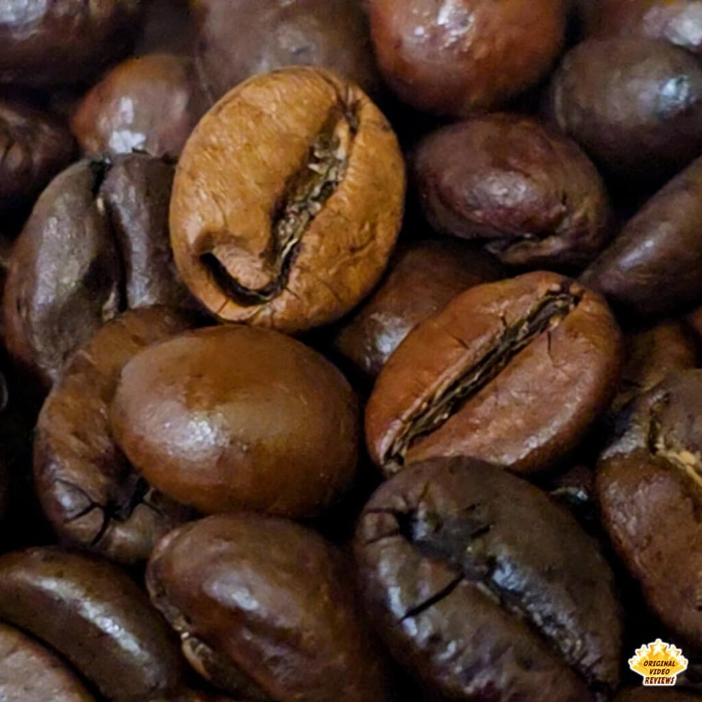 Extreme close-up of Bristot Classico Oro coffee beans showing natural variation in size and color - a blend of Arabica and Robusta beans with a balanced medium roast.