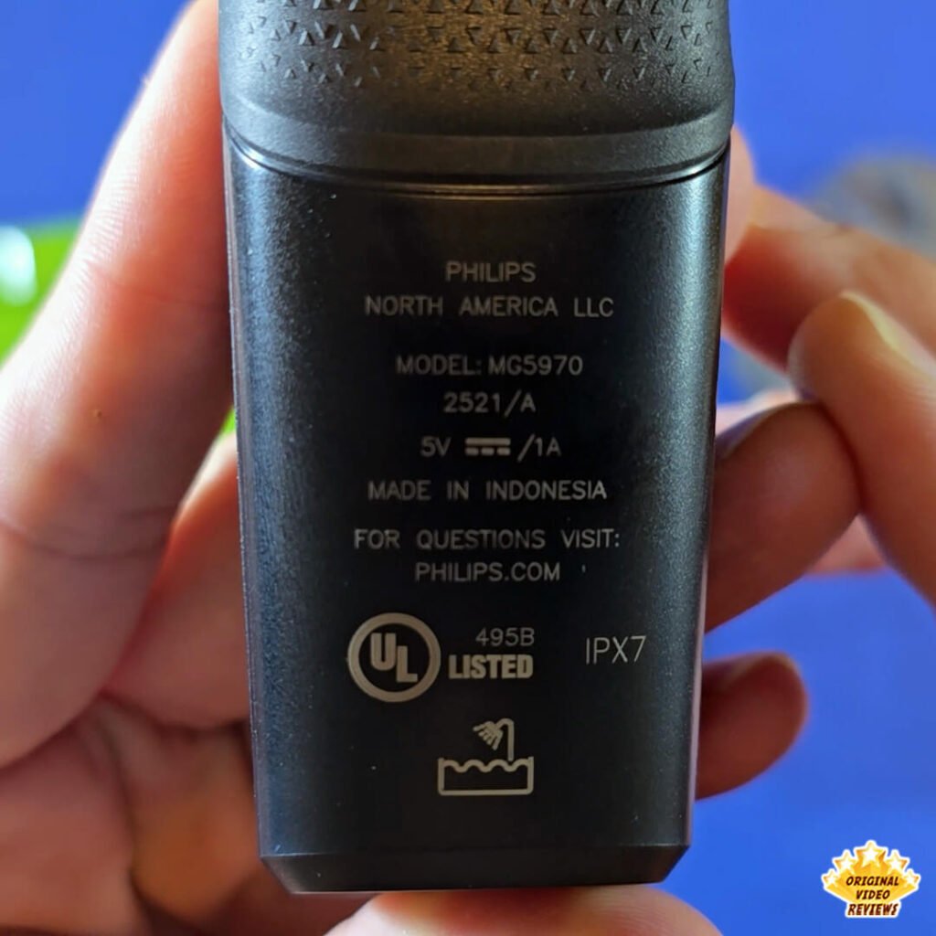 Close-up of the Philips Norelco Multigroom 5000 MG5970/49 back panel showing model details, manufacturing info, and waterproof rating.