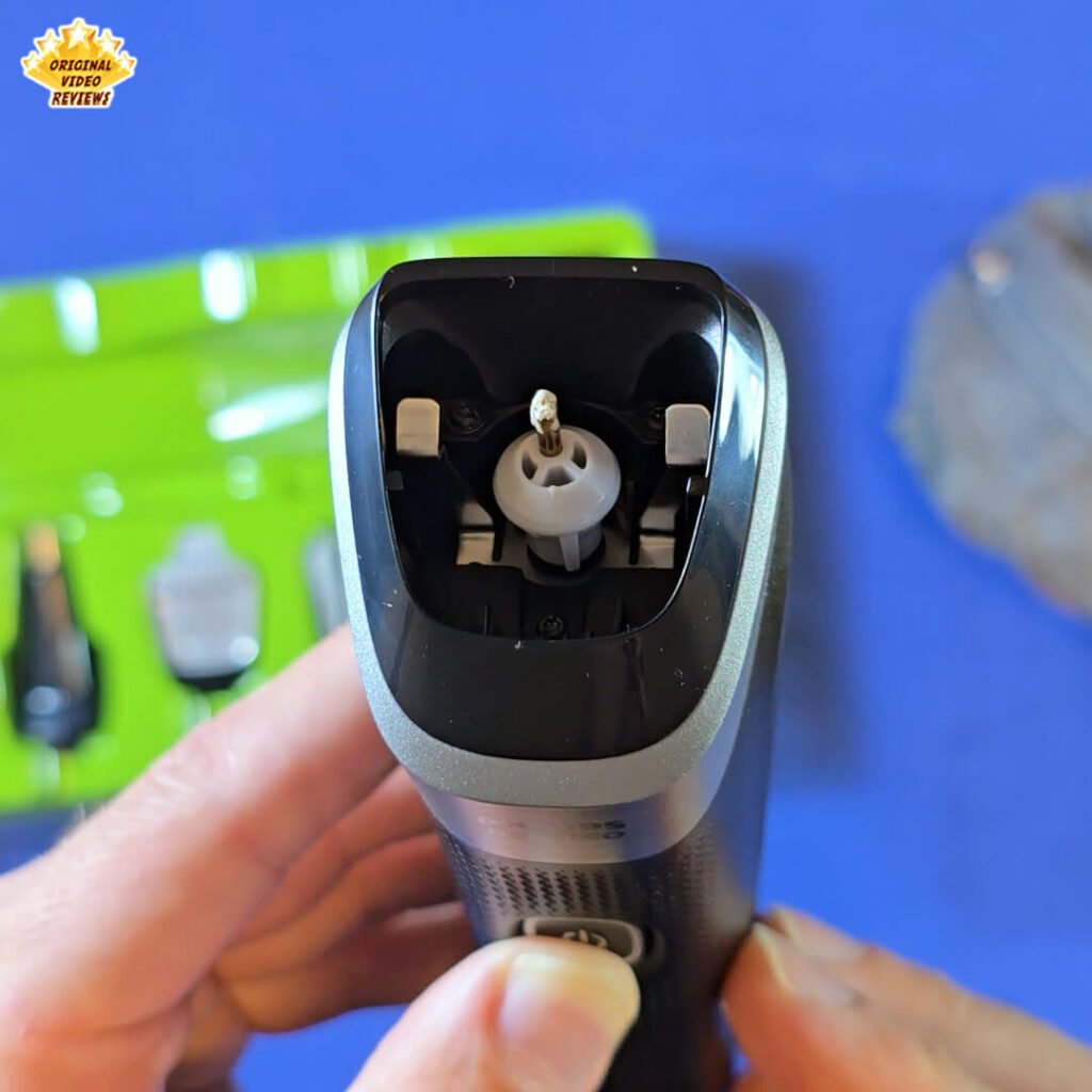 Close-up of the Philips Norelco Multigroom 5000 MG5970/49 with the trimming head removed, showing the motor mechanism and internal lubrication.