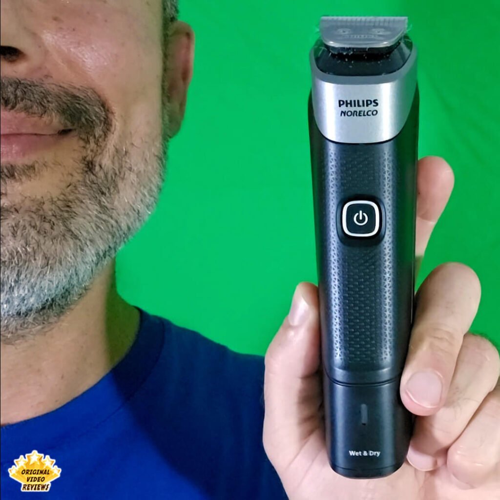 The OVR Guy holding and presenting the Philips Norelco Multigroom 5000 MG5970/49 trimmer to the camera in front of a green background.
