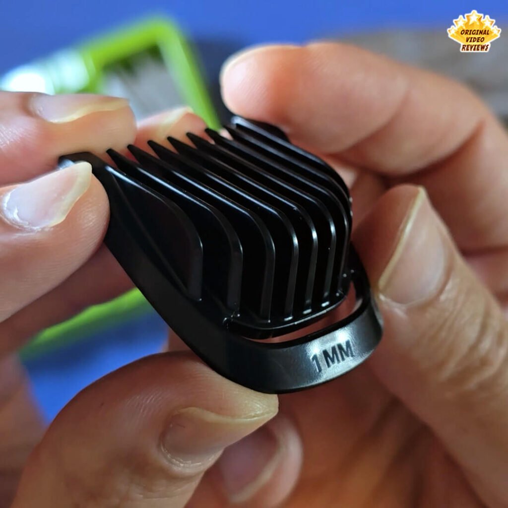 The 1 mm stubble comb from the Philips Norelco Multigroom 5000 MG5970/49 grooming kit, held close to the camera.