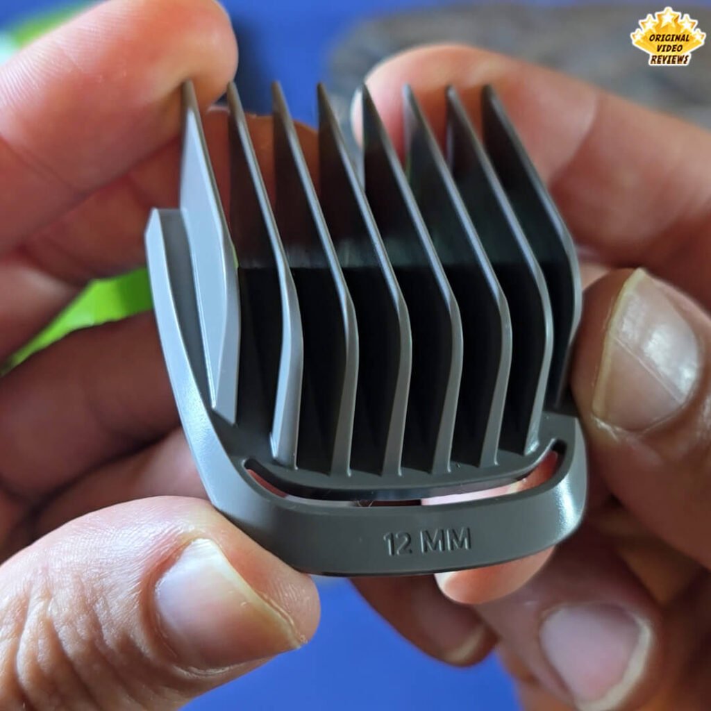 Close-up of the Philips Norelco Multigroom 5000 12 mm gray hair comb attachment labeled “12 MM.”