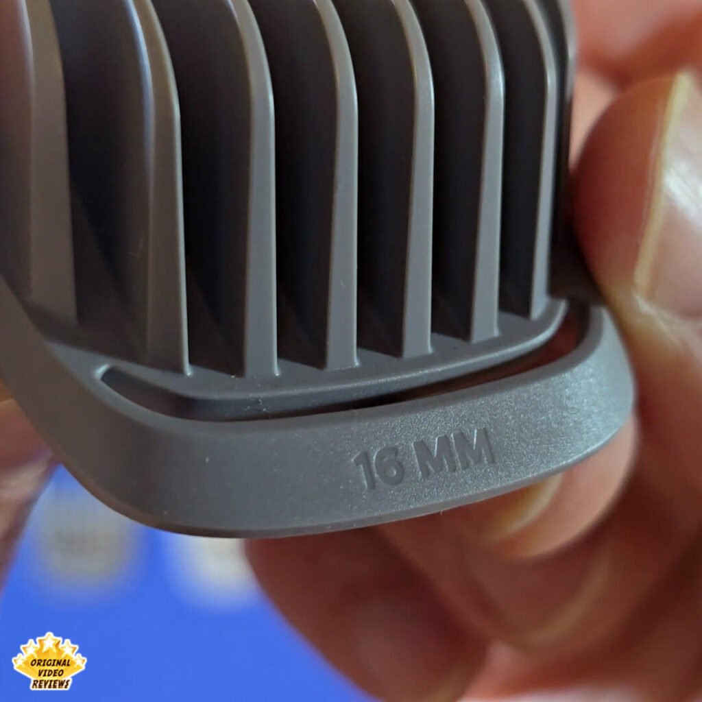 Close-up of the Philips Norelco Multigroom 5000 16 mm gray hair comb attachment labeled “16 MM.”