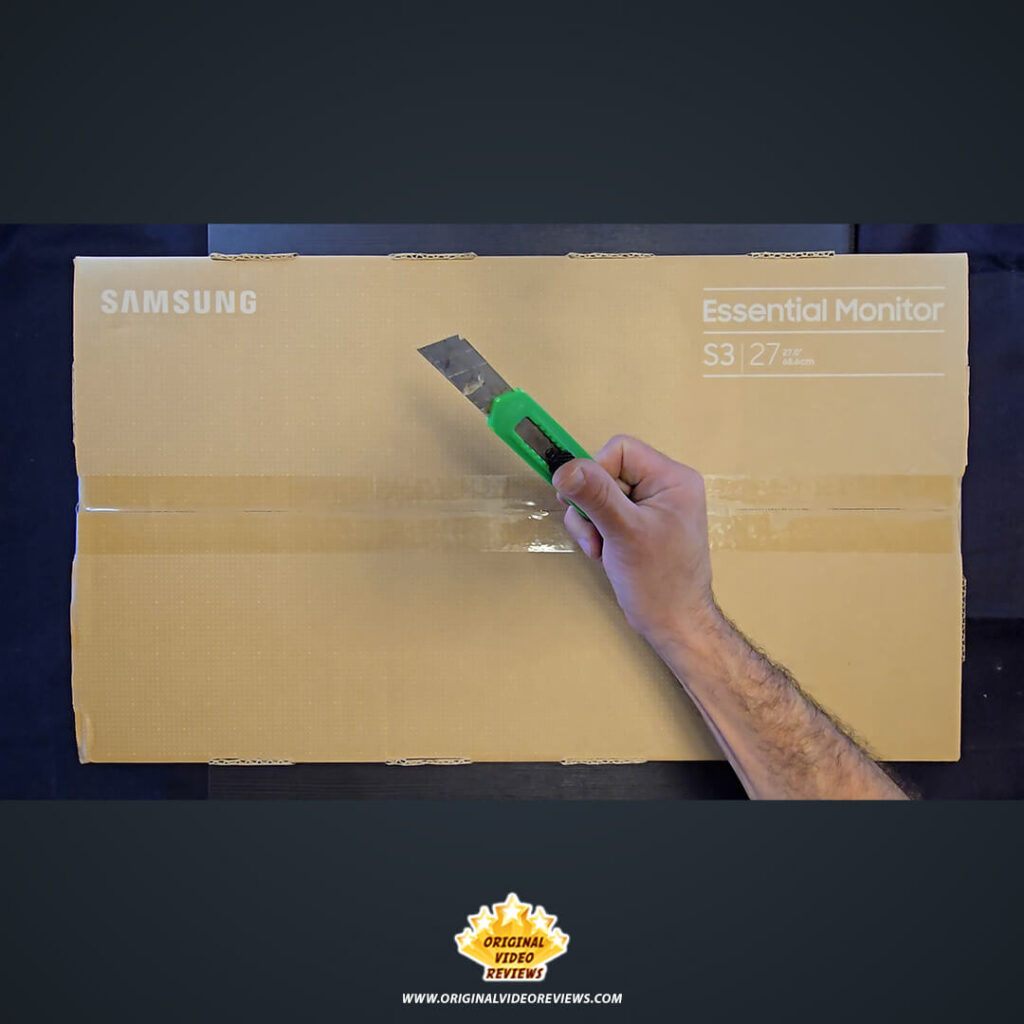 The OVR Guy using a utility knife to open the Samsung Essential Monitor S3 27-inch retail box.