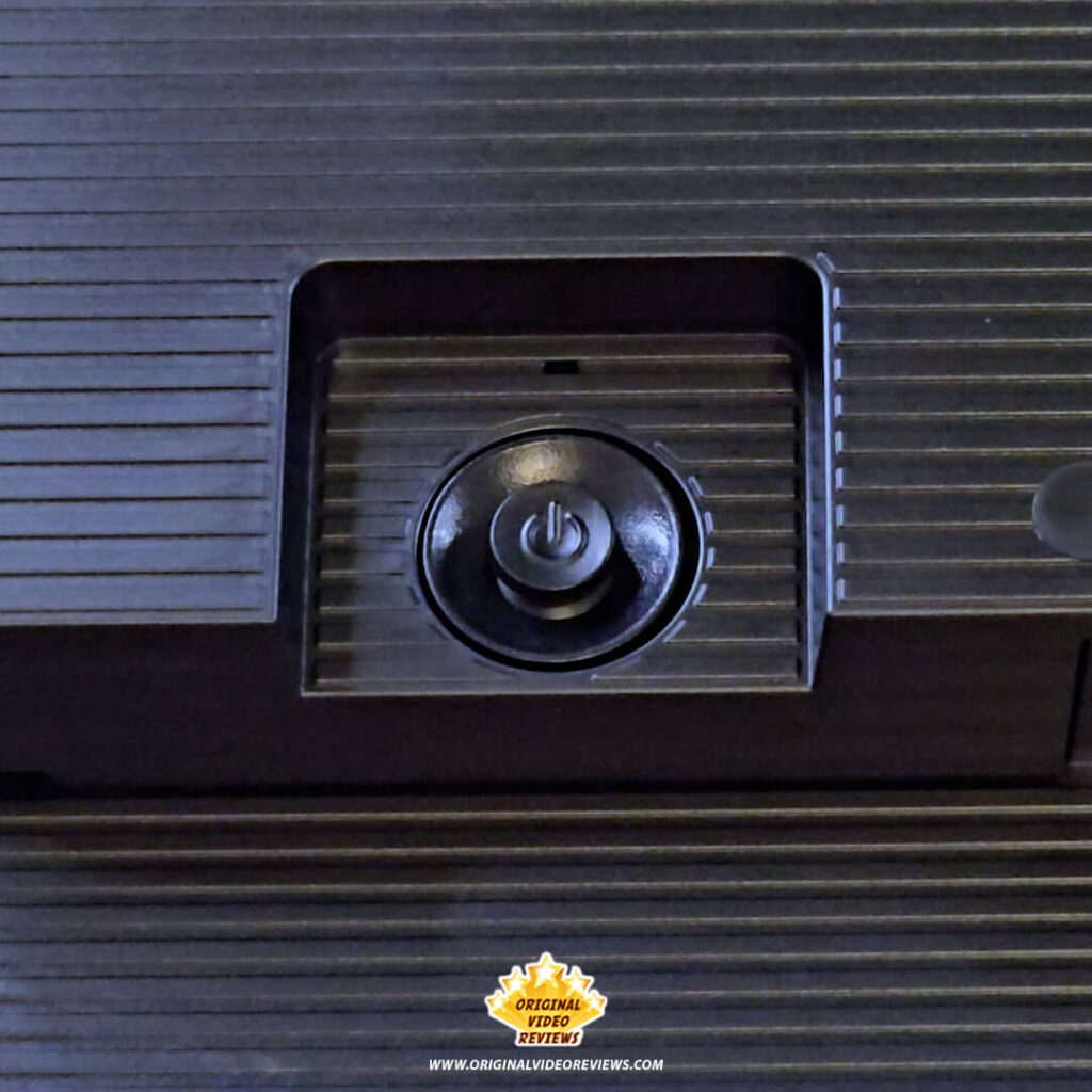 Close-up view of the circular power and OSD control joystick on the textured back panel of the Samsung Essential Monitor S3.