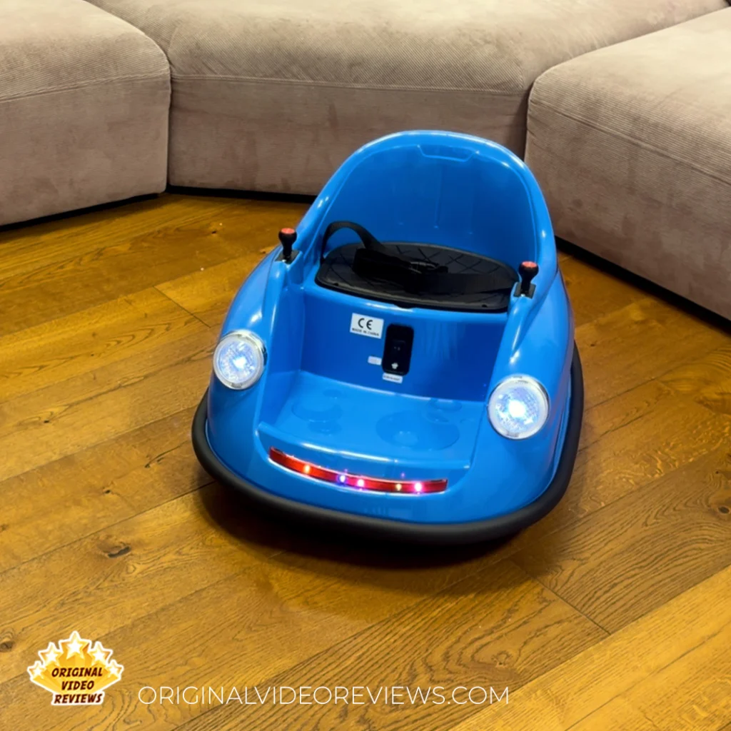 Blue electric bumper car for kids on a wood floor with headlights and red LED light strip lit up