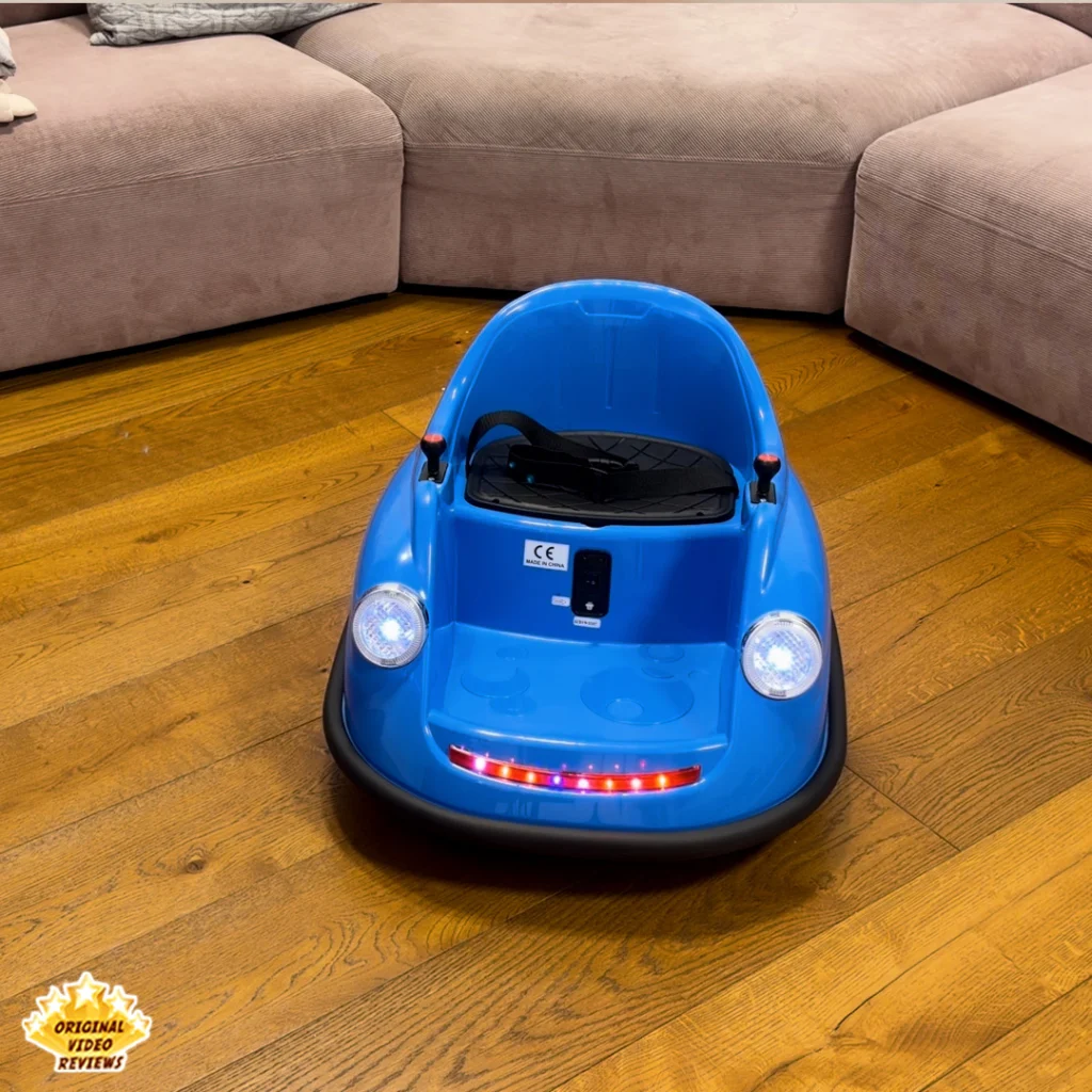 Full front view of the blue Electric Bumper Car for Kids on a wood floor with both headlights and the LED light strip lit