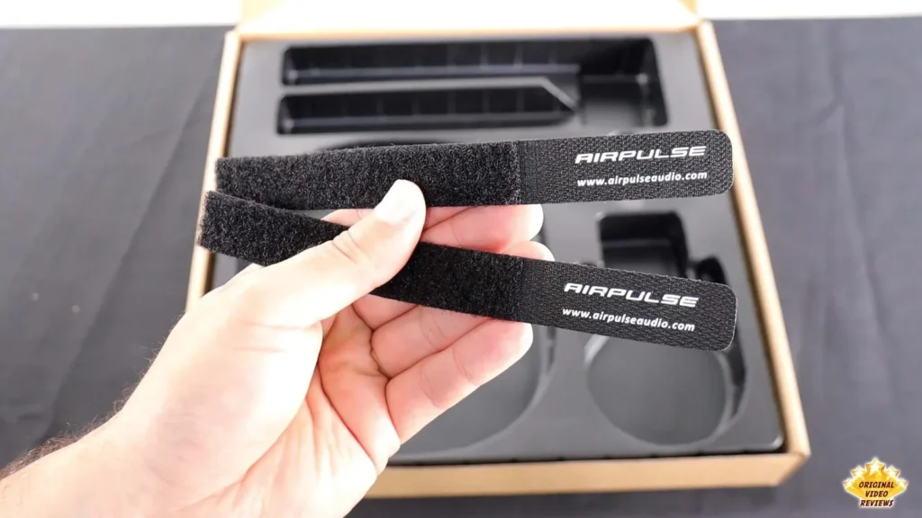 Hand holding a black AIRPULSE hook-and-loop cable tie