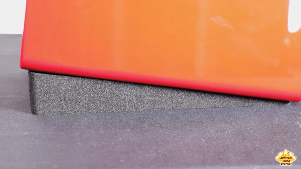 Close-up of the gray foam stand under the red AIRPULSE A100 speaker