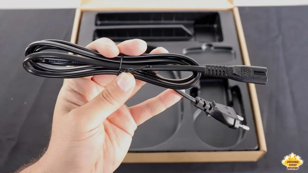 Hand holding the black power cable of the AIRPULSE A100