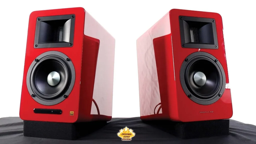 Two red AIRPULSE A100 speakers side by side, one facing forward and the other angled