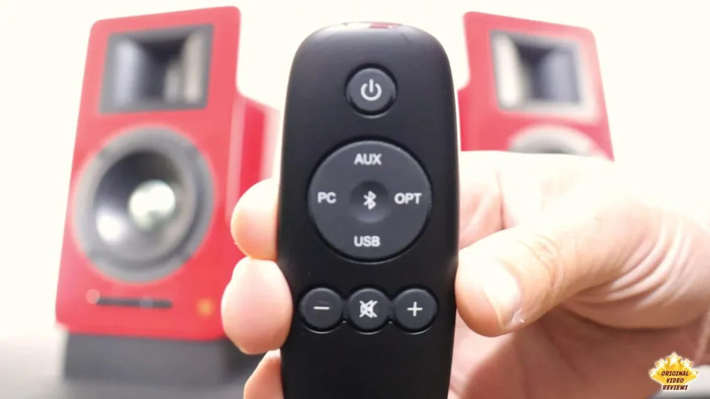 Close-up of the AIRPULSE A100 remote control with power, input, Bluetooth, mute and volume buttons