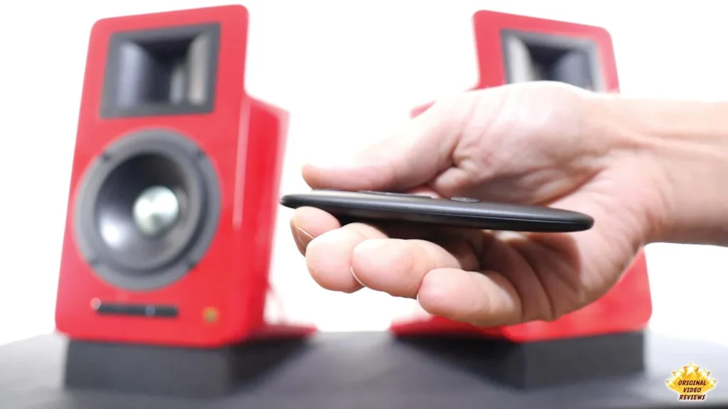 Hand holding the thin AIRPULSE A100 remote control from the side