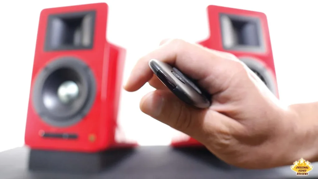 Hand holding the AIRPULSE A100 remote control tilted toward the camera