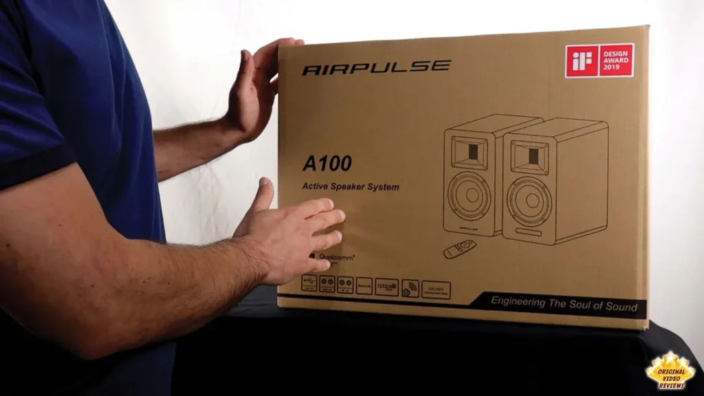 Reviewer holding the AIRPULSE A100 retail box against the front of a table
