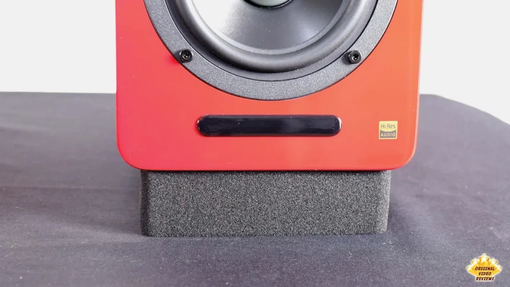 Red AIRPULSE A100 speaker resting on a gray foam stand