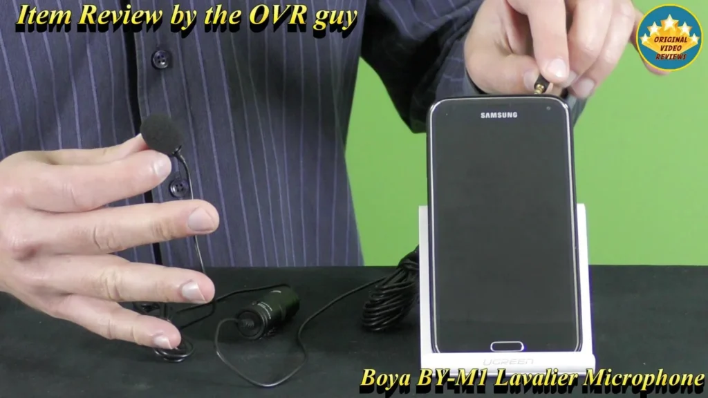 BOYA BY-M1 Lavalier Microphone plug being connected to a Samsung smartphone on a stand