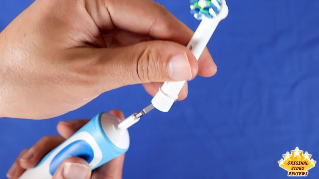 Hands holding the Oral-B Vitality handle and a CrossAction brush head being attached