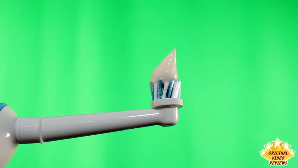 Oral-B CrossAction brush head held out against a green background