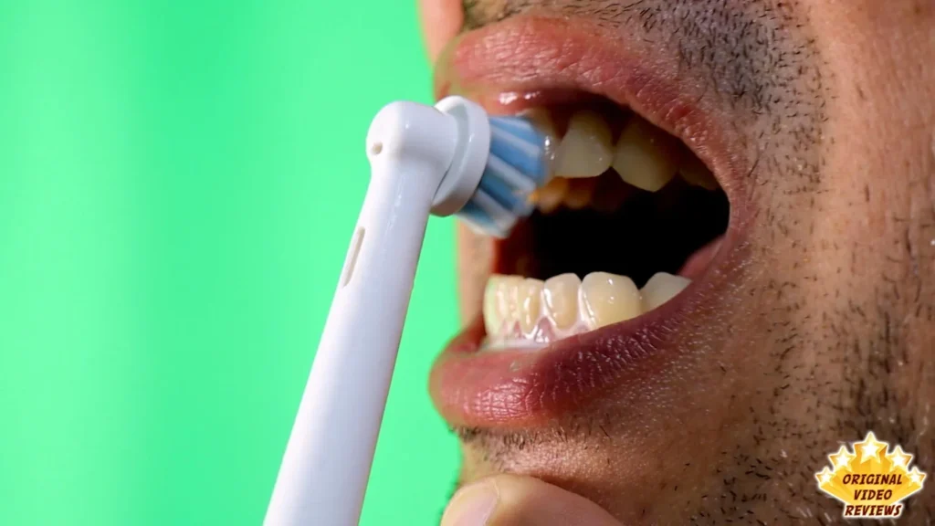 Person brushing their teeth with the Oral-B Vitality electric toothbrush, green background