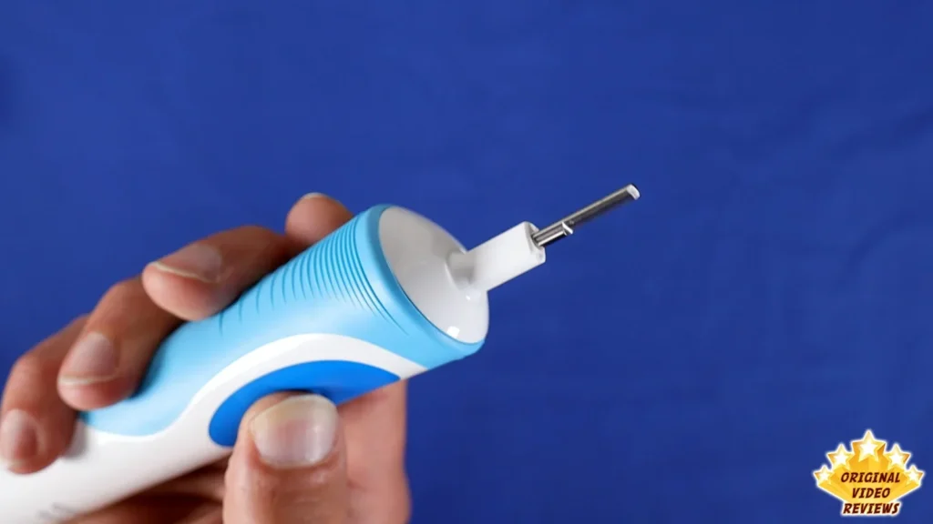 Hand holding the Oral-B Vitality handle without a brush head, blue background