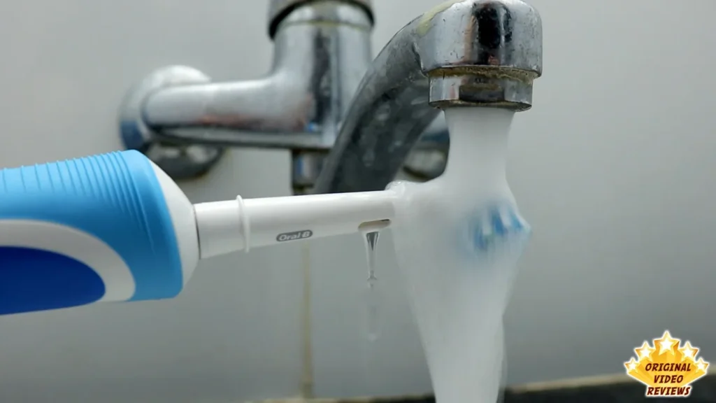 Oral-B Vitality brush head held under running water from a tap